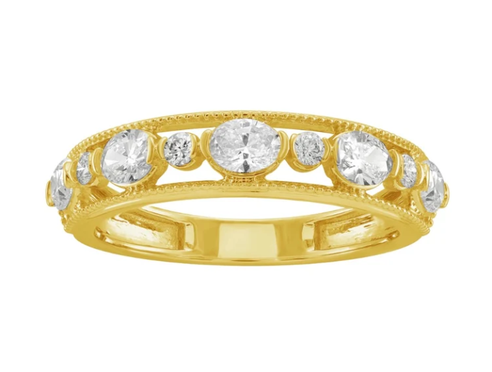 A gold ring has a row of diamonds in large and small alternating sizes. There are open spaces between the diamonds.